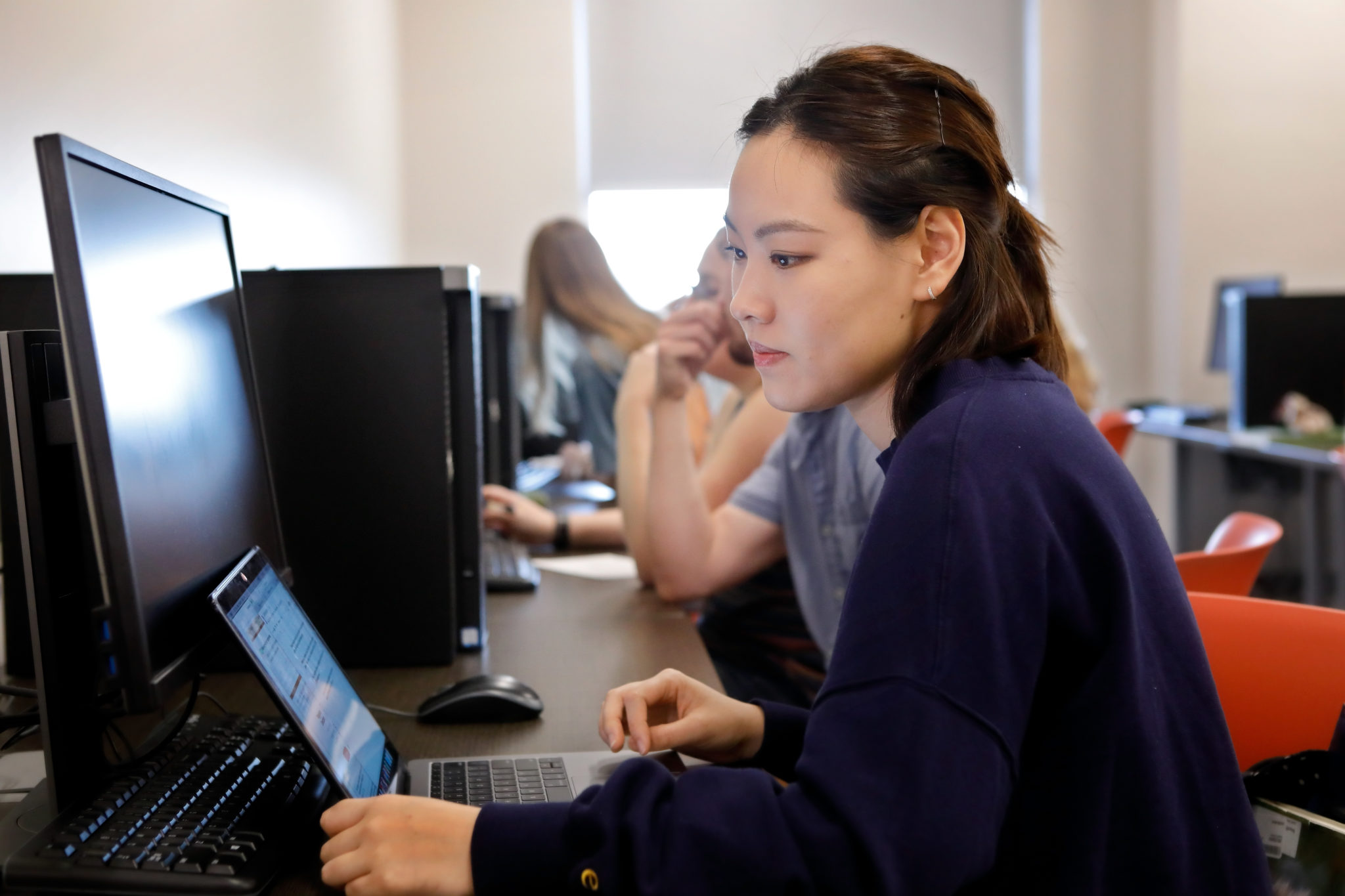 A student works at a computer in a computer science class