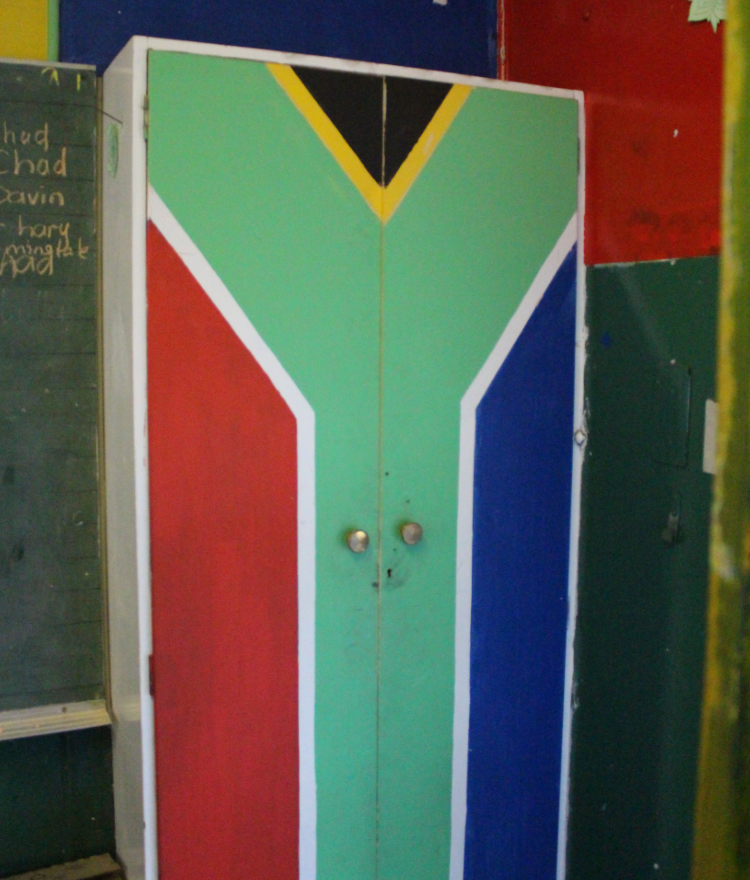 The South African flag is painted on a cabinet in a classroom in South Africa.