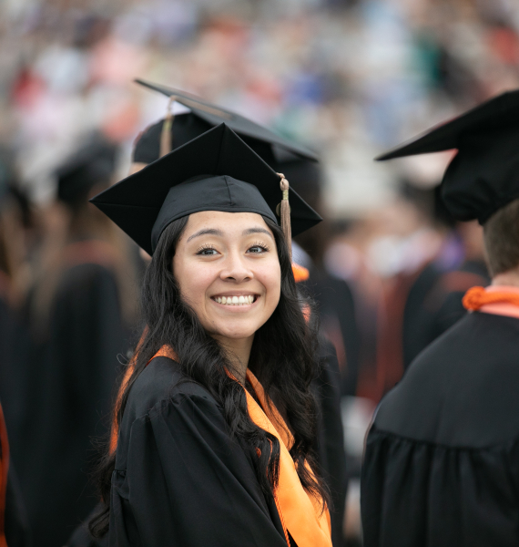 a smiling student wearing a cap and gown
