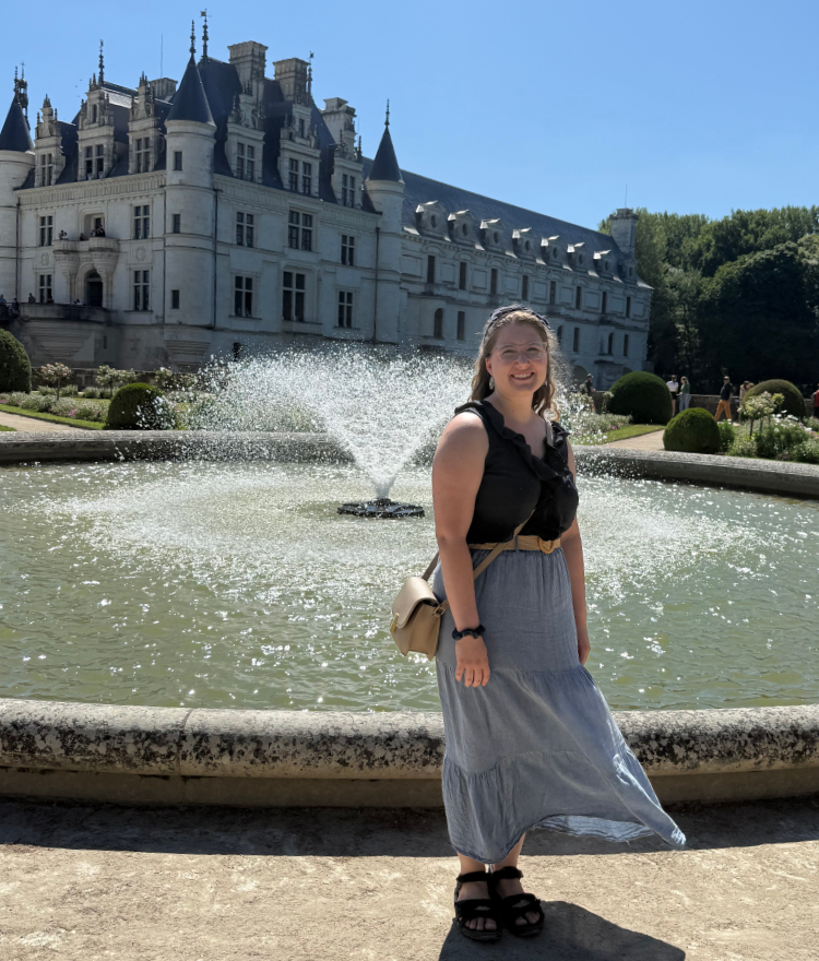 A Mercer student stands in front of a French castle.
