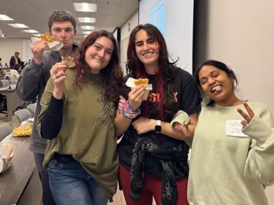 Four smiling Mercer students eat cookies at a Biology Mentorship Program event.