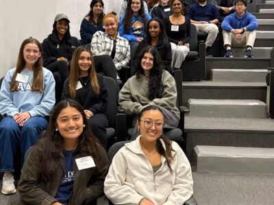 Nineteen mentors sit in an auditorium.