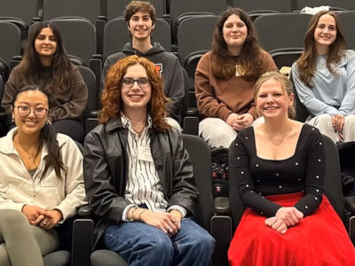 Fourteen mentors sit in an auditorium.