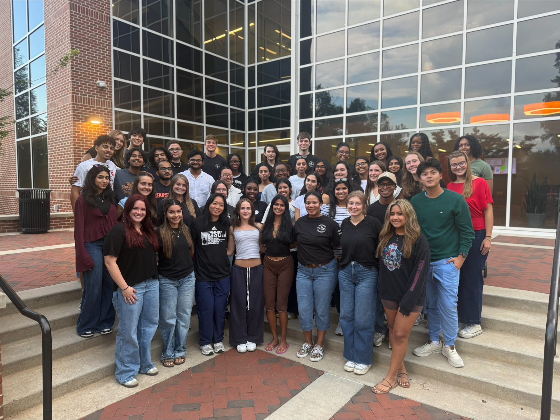 A large group of Mercer biology mentors stands in front of the Godsey Science Center.
